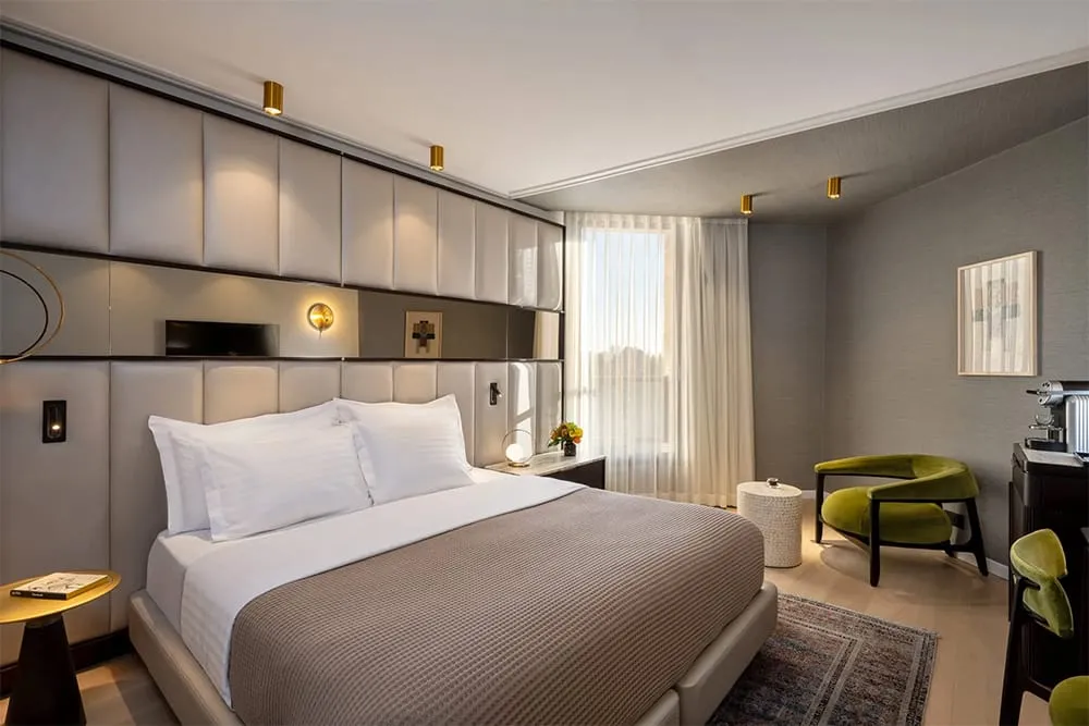 Inbal Hotel Jerusalem deluxe room with king bed and warm lighting